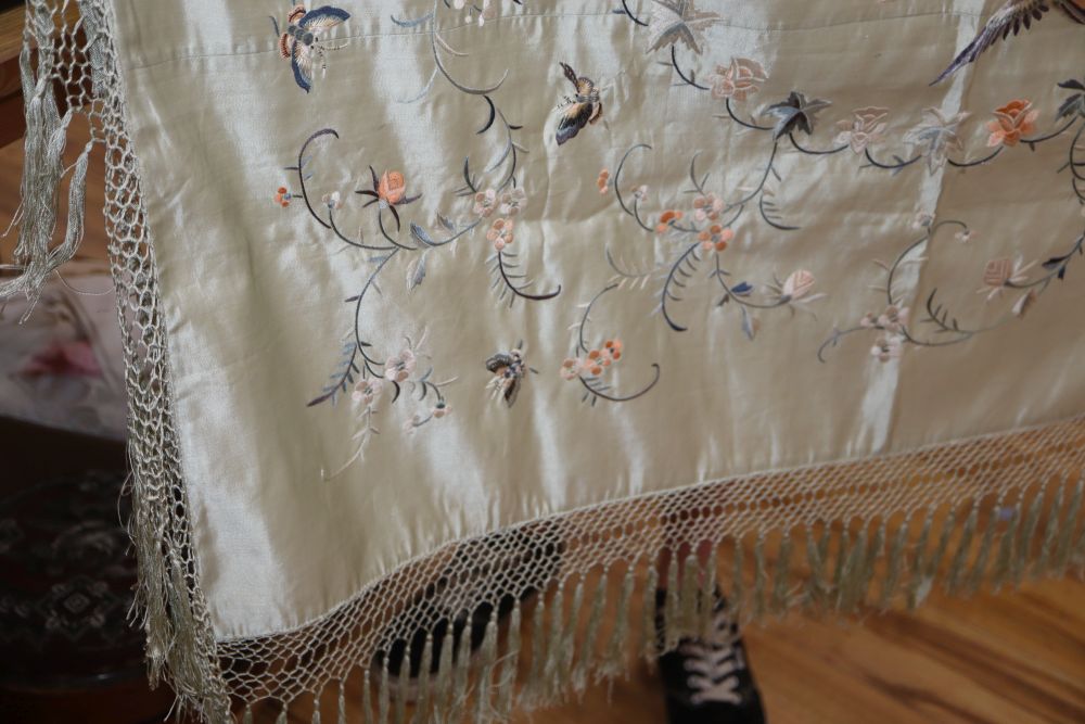 A late 19th century Chinese embroidered and fringed cover, decorated with flowers and butterflies on a pale turquoise background